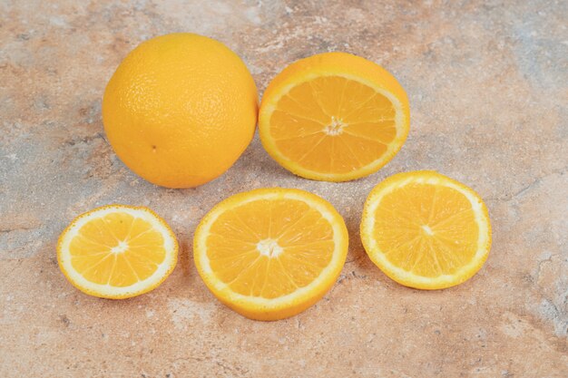 Fresh whole orange and slices on marble background. High quality photo