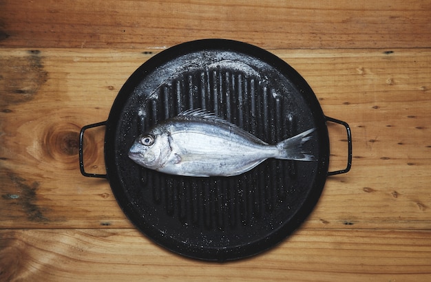 Fresh wild sea bream on grill pan ready to cook