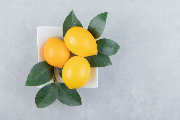 Free photo fresh yellow lemons on white plate.