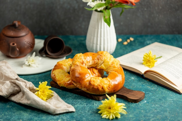 Freshly baked buns in round shape, yellow flowers and open book