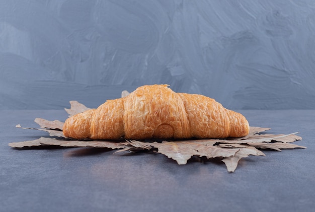 Free photo freshly baked french croissant on grey background.