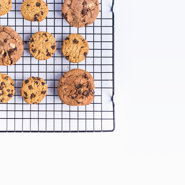 Free photo freshly baked homemade chocolate chip cookies on an oven net on a white background