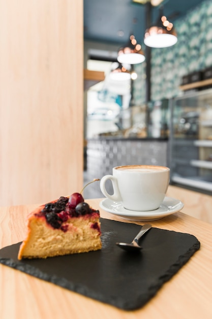 Freshly baked pastry with cup of coffee on wooden table