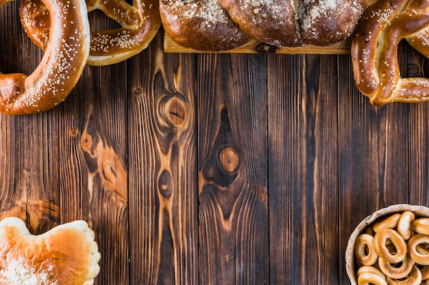 Freshly baked plaited loaf and pretzels on the wooden table with copy space