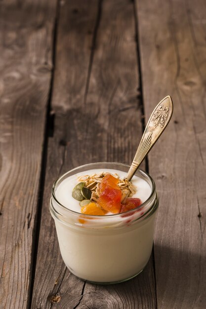 Freshly yogurt with healthy toppings on an old table