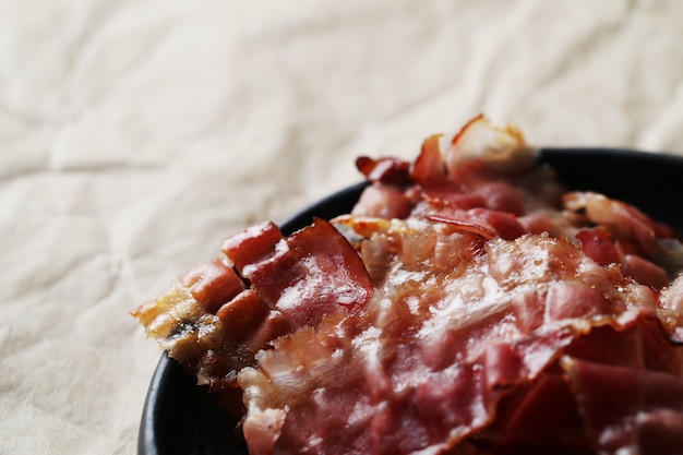 Free Photo fried bacon on black plate