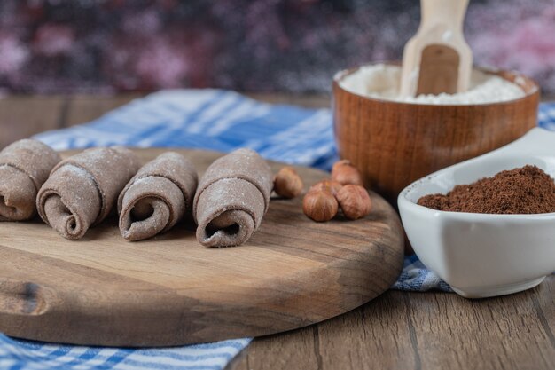 Fried caucasian mutaki cookies on a wooden board with cinnamon powder.