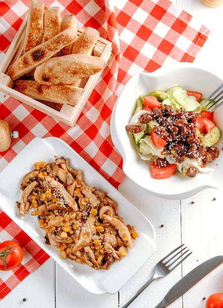 Fried chicken breast slices with corn and vegetable salad