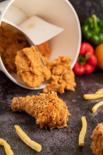 Free photo fried chicken and french fries on black cement floor.