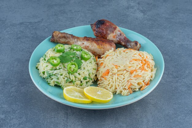 Fried chicken legs and rice on blue plate. 