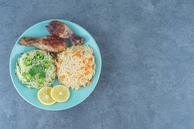 Fried chicken legs and rice on blue plate. 