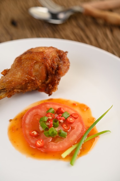 Free Photo fried chicken legs on a white plate with sauce.