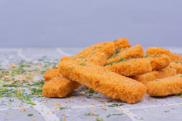 Fried chicken nuggets with crispy topping on blue backgroun.