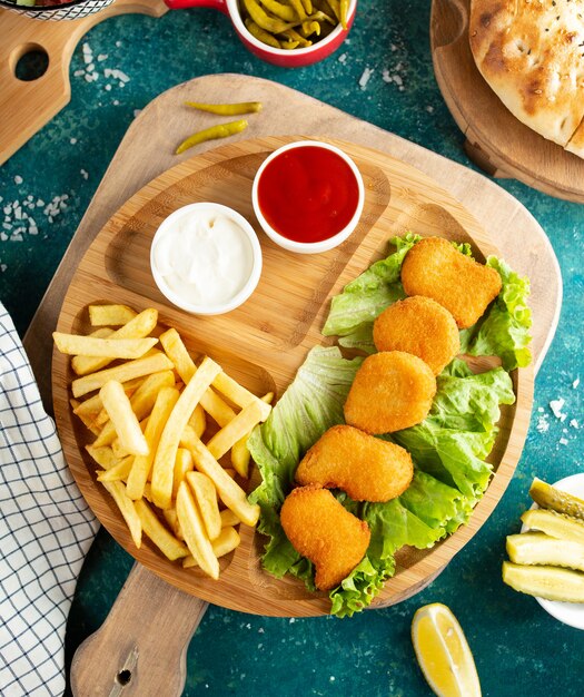 Fried chicken nuggets with french fries top view