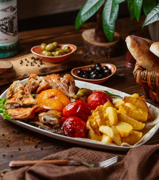 fried chicken pieces with fried potato, grilled vegetables