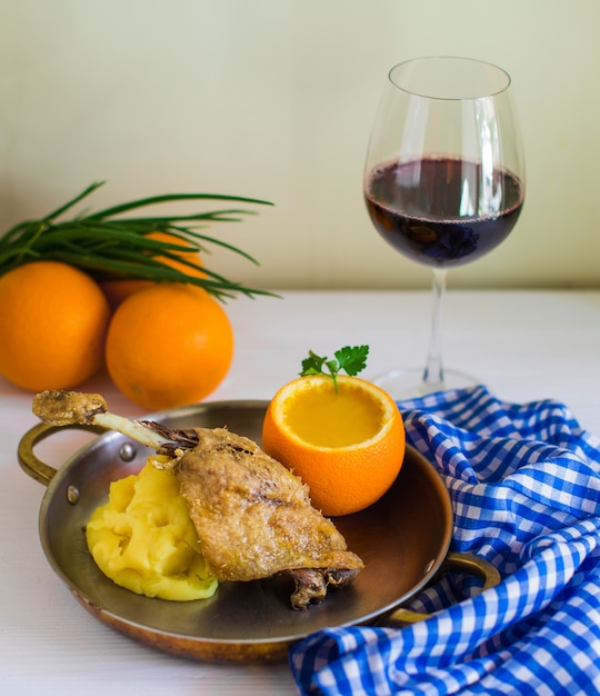 Fried chicken served with mashed potato and lentil soup in orange skin bowl