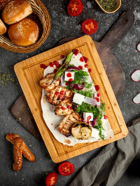 Free photo fried chicken with greens, cheese on a wooden board