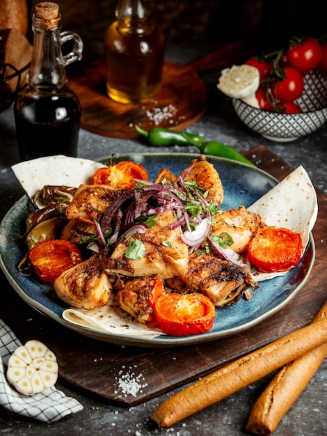 Fried chicken with tomato slices and onions