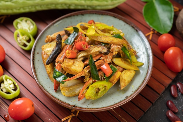 Fried crab with curry powder in a plate with bell peppers and tomatoes.