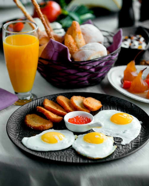 Free photo fried crutones with fried eggs and orange fresh