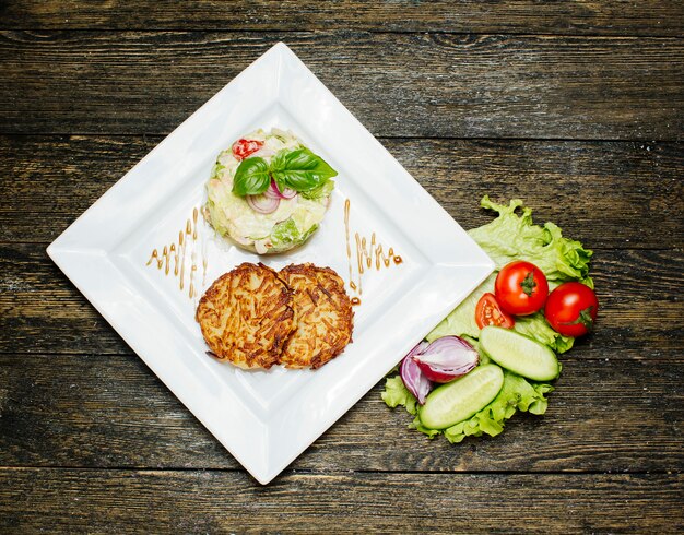 Fried cutlets with salad topped with cream