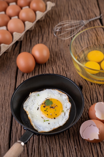 Free photo fried eggs in a frying pan and raw eggs, organic food for good health, high in protein