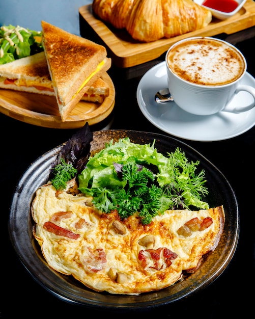 Fried eggs with mushrooms served with greens sandwiches and cup of coffee