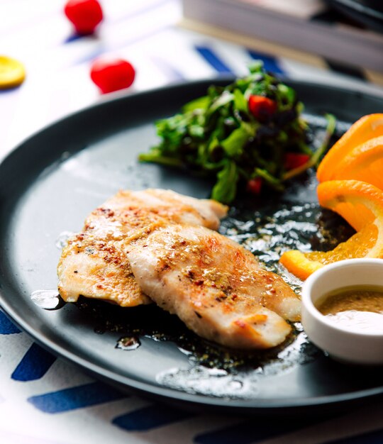 Fried fillet with sliced orange and herbs