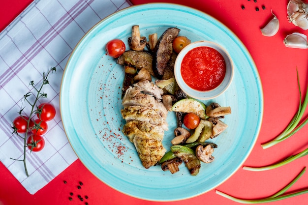 Fried fish fillet with side vegetables and mushrooms