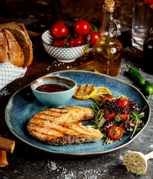 Fried fish slice with herbs and vegetables and sauce