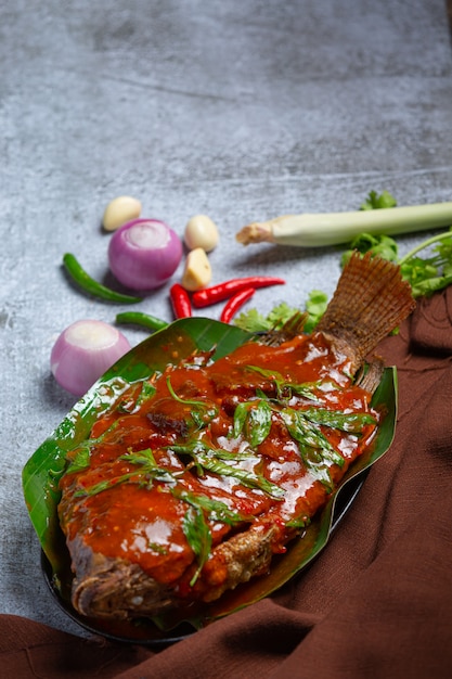 Free Photo fried fish topped with chili sauce, thai food.