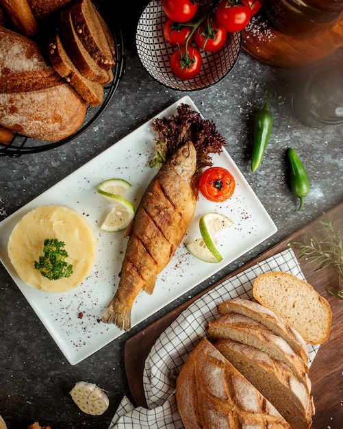 Fried fish with potato mash and tomato