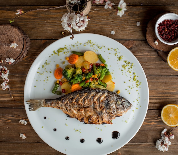 fried fish with vegetables in the plate 