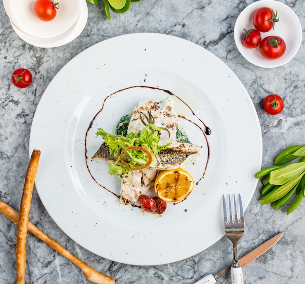 fried fish with vegetables top view