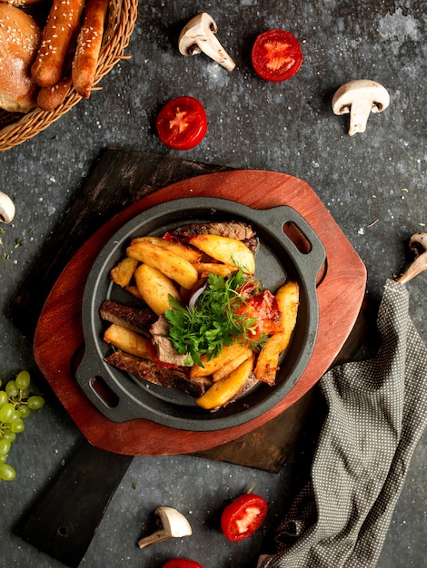 Free photo fried meat and potatoes in an aluminum skillet