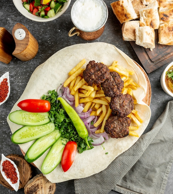 Free photo fried meat served with herbs, vegetables and french fries