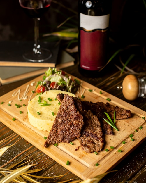 Fried meat served with mashed potatoes and salad