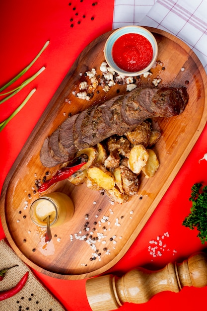 Fried meat slices with fried potato and ketchup