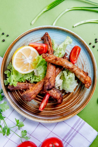 fried meat with lettuce tomatoes and lemon