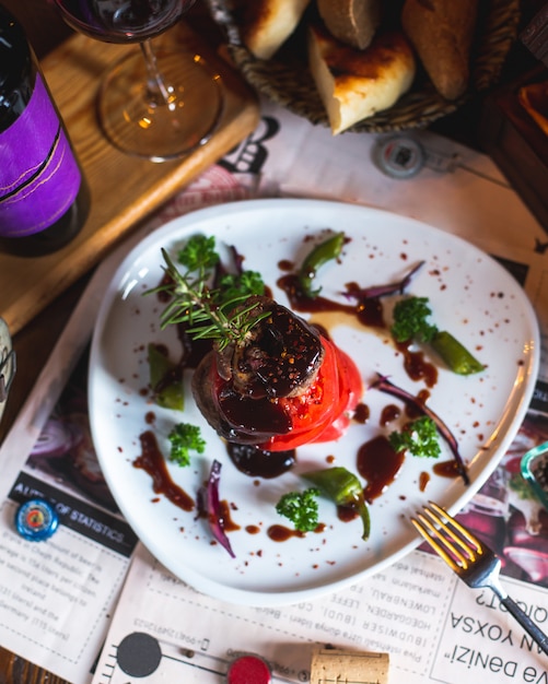 Free photo fried meat with tomato slices, greens, sauce and rosemary sprig 2