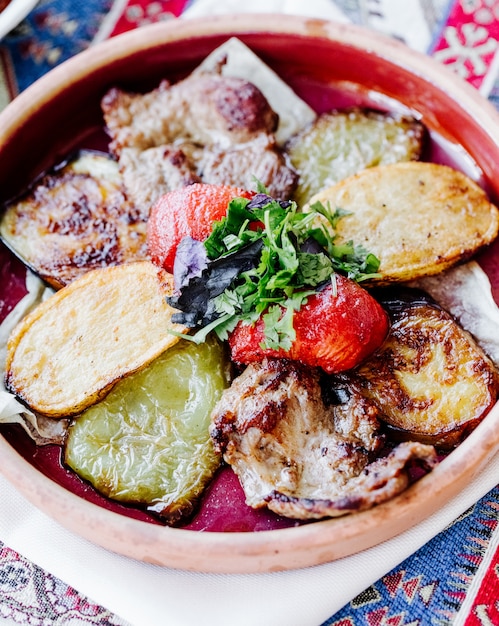 Free photo fried potato slices with meat barbecue , tomato and herbs.