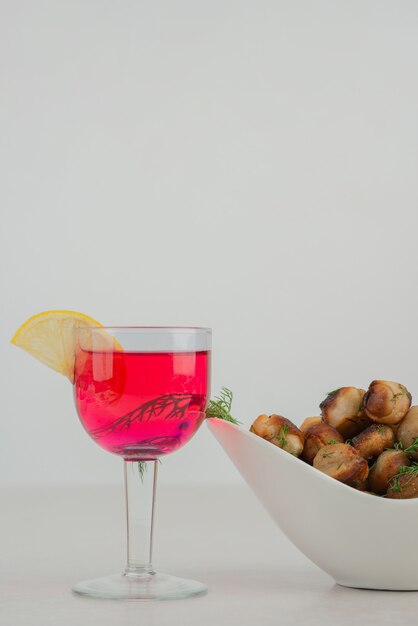 Fried potato on white plate with lemonade .