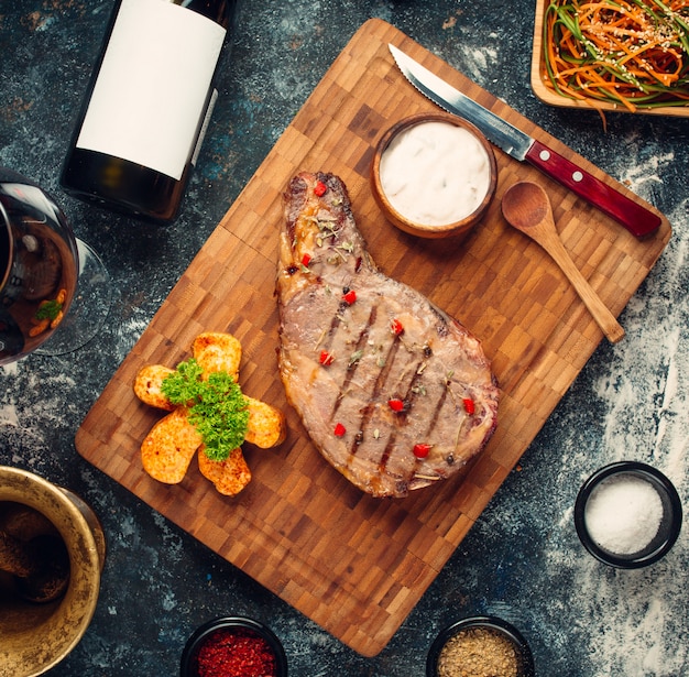 Fried rib eye steak on wooden board