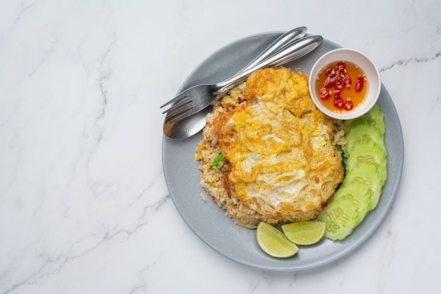 Free photo fried rice and fried egg served with fish sauce and cucumber