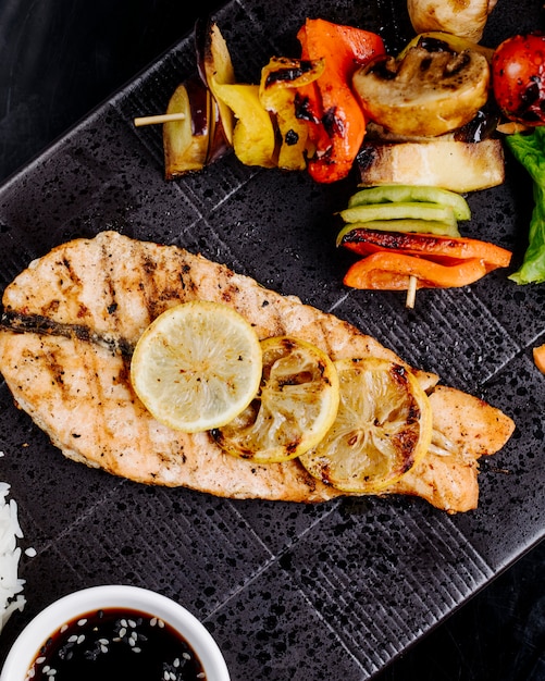 fried salmon steak with lemon slices on top