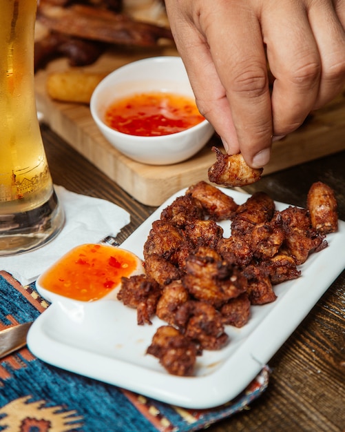 Free photo fried snack with sweet chili sauce and beer