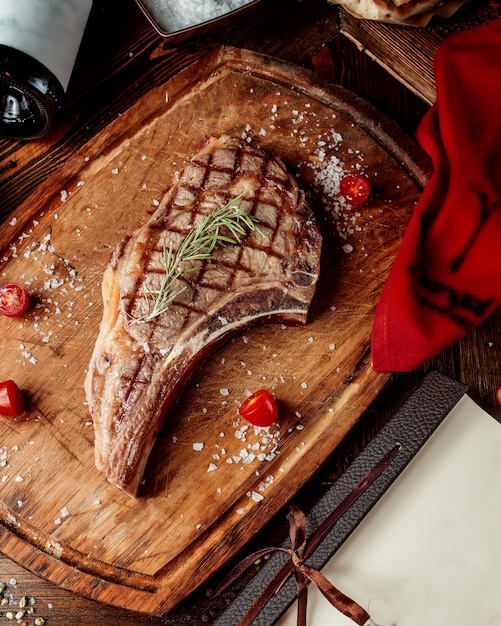 Free photo fried steak piece processed with spices on a wooden board