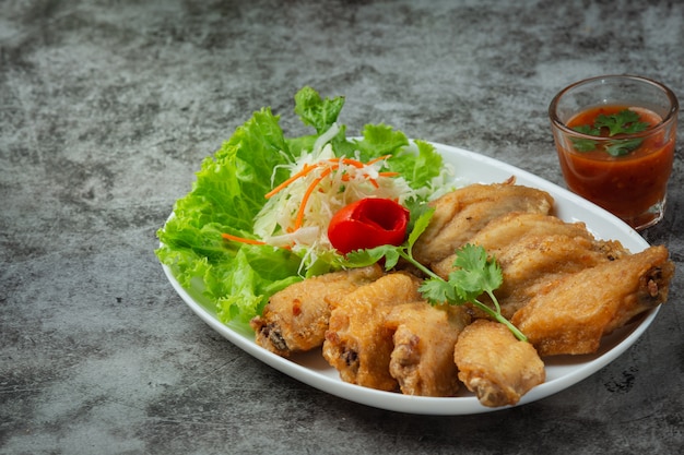 Free Photo fried wings with fish sauce, beautifully decorated herbs and served.