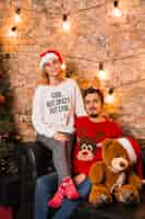 Free photo friendly couple celebrating christmas with teddy bear