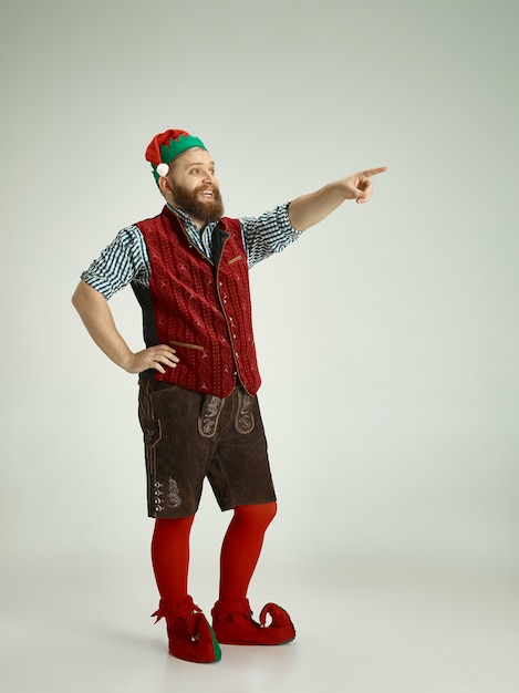 Free photo friendly man dressed like a funny gnome posing on an isolated gray